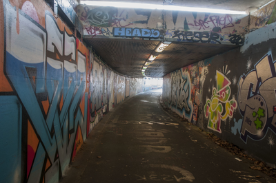 825711 Gezicht in de fietstunnel onder het Westplein te Utrecht, uit het noorden, met op de wanden graffiti.N.B. De ...